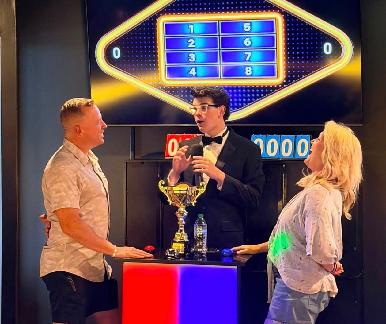 Two players facing off at the buzzer podium during Friendly Feud