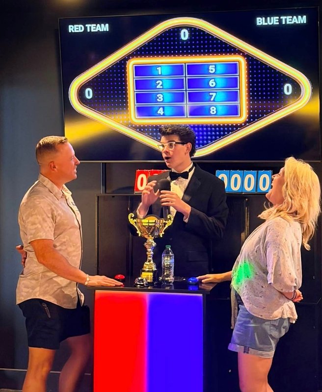 Two players facing off at the buzzer podium during the Friendly Feud round
