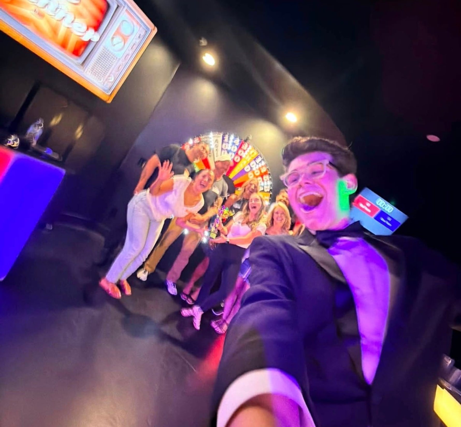 Game show host taking a selfie with a cheering group at ClueClock Gameshow