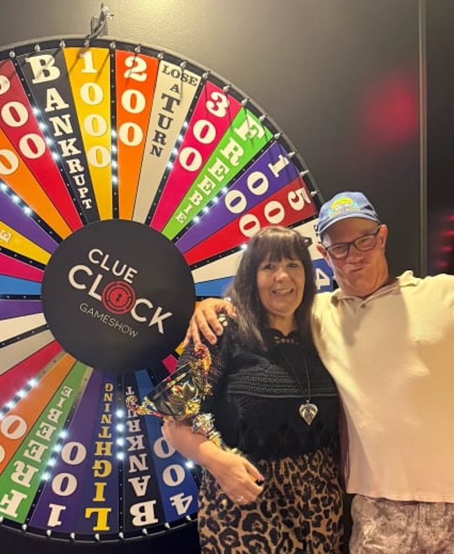 Two guests celebrating a win in front of the Spin To Win prize wheel