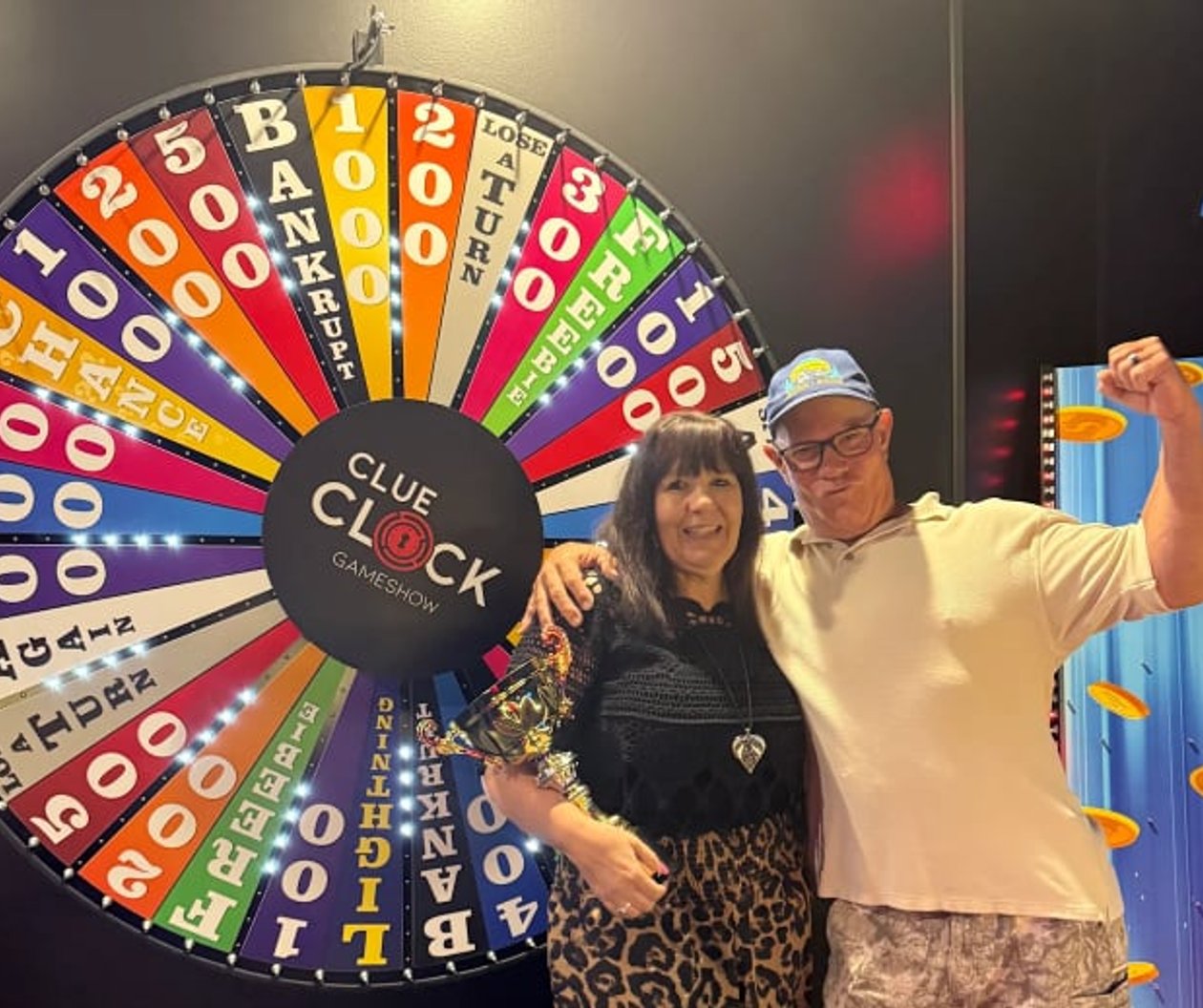 Two guests celebrating in front of the Spin To Win prize wheel