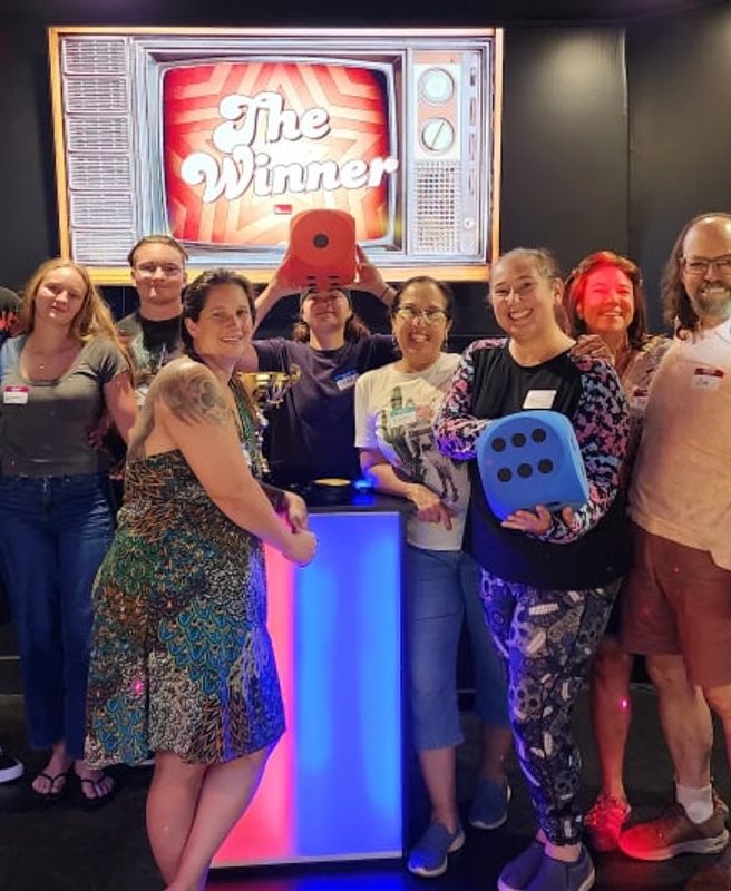 Team celebrating in front of The Winner screen at ClueClock Gameshow